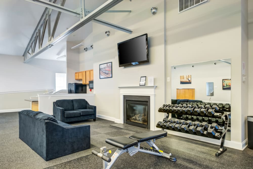 Lounge area with a fireplace and a wall mounted tv at Melrose Station Apartments in Elkins Park, Pennsylvania