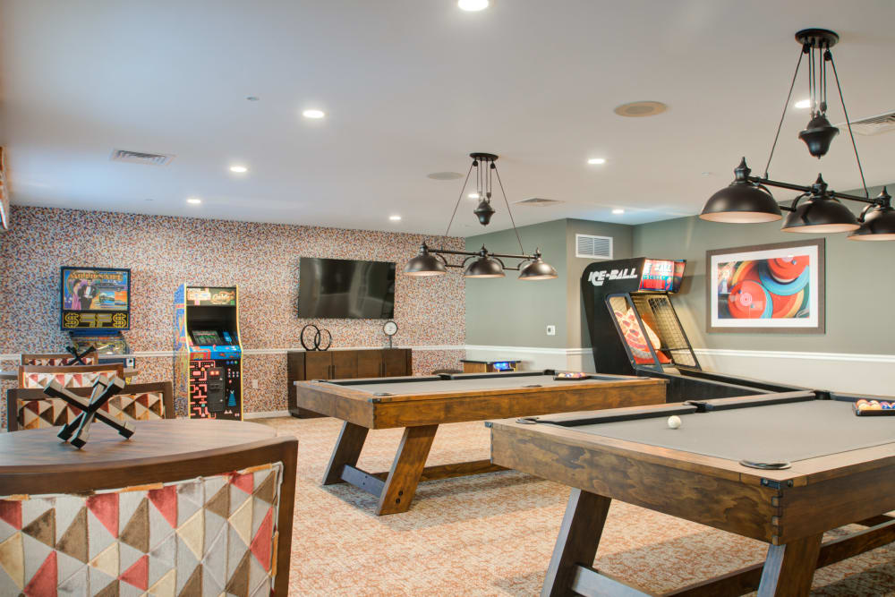 Game room with skee-ball, arcade cabinets, and pool tables at Mercer Hill at Doylestown in Doylestown, Pennsylvania