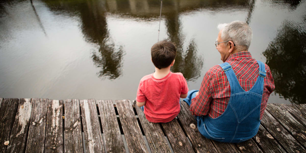 Resident sitting with a young family member on a dock at Citrus Place in Riverside, California