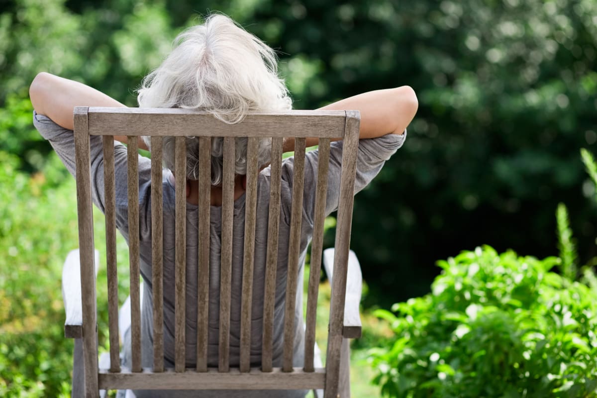 Resident sitting in a wooden chair sunbathing at Ashley Pointe in Lake Stevens, Washington