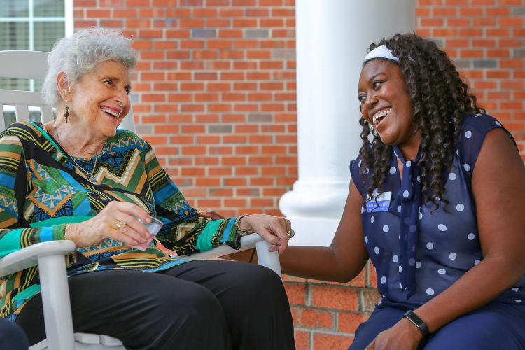 A resident holding hands with her daughter outside at The Harmony Collection at Columbia in Columbia, South Carolina