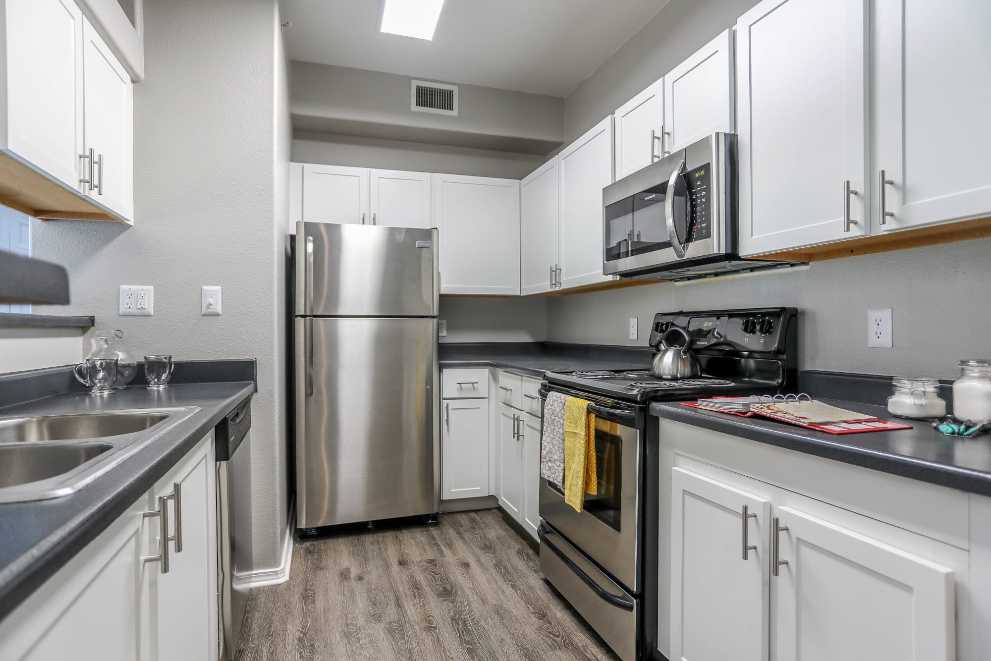 White cabinetry in a renovated kitchen at Promenade at Hunter's Glen Apartments in Thornton, Colorado