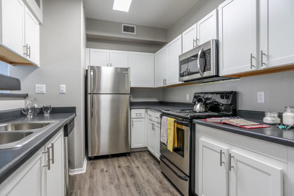 Kitchen with wood-style flooring at Promenade at Hunter's Glen Apartments in Thornton, Colorado