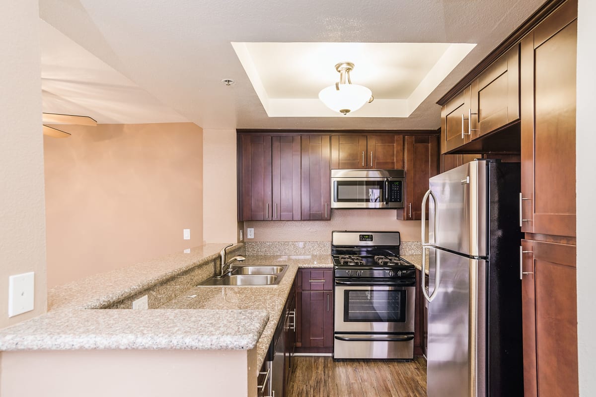 Kitchen with stainless-steel appliances and granite countertops at Marlon Manor Apartments, Los Angeles, California