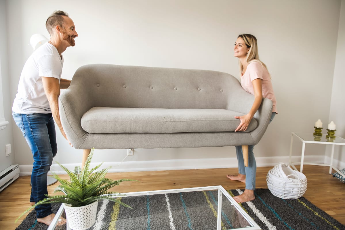 Couple moving couch into storage at Devon Self Storage in Grand Rapids, Michigan