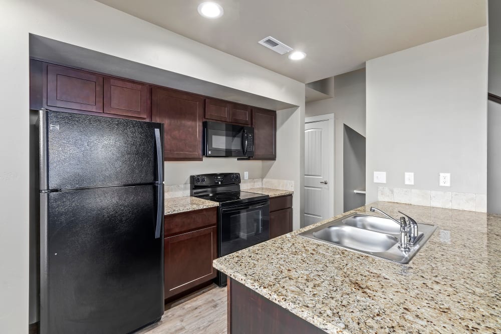 Kitchen with dark cabinetry at Cedar Park & Canyon Falls Townhomes in Twin Falls, Idaho