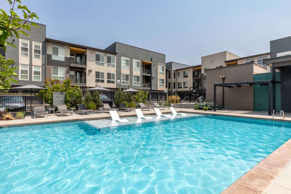 Swimming pool area with loungers at Encore Evans Station in Denver, Colorado