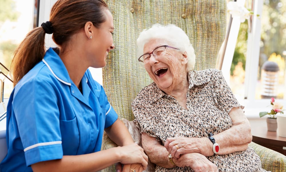 Resident sitting and talking to a nurse at Randall Residence