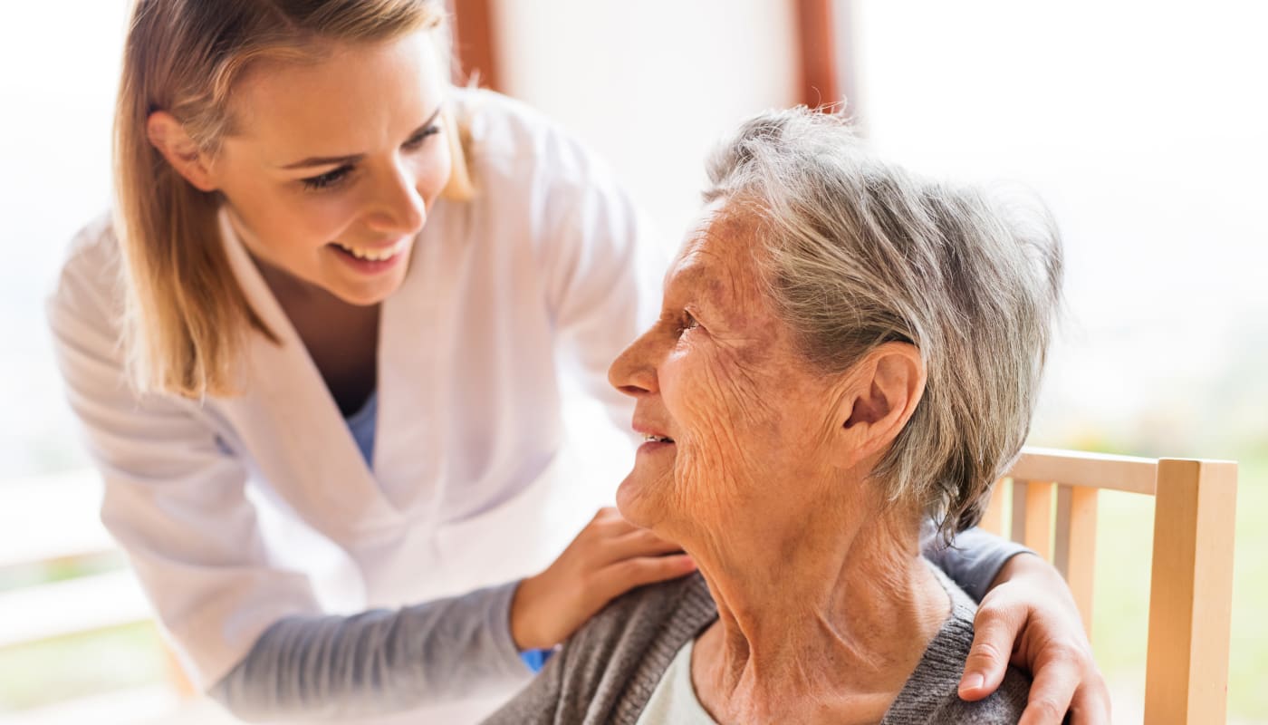 Staff member helping a female resident at Willow Creek Senior Living in Elizabethtown, Kentucky.