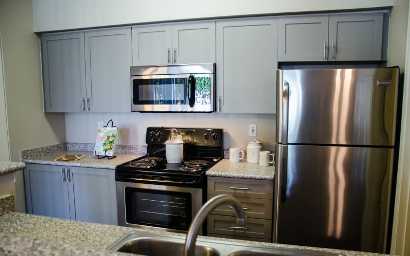 Trendy grey cabinetry in a kitchen at Wildreed Apartments in Everett, Washington