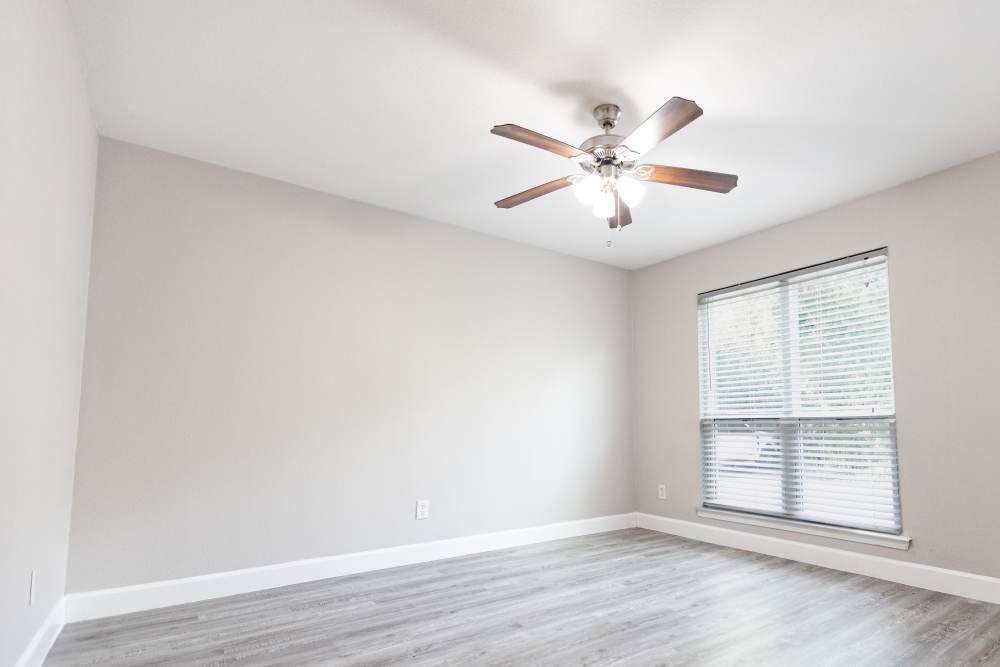 Spacious and inviting bedroom with modern finishes and ample natural light at San Mateo Forest in Dallas, Texas.