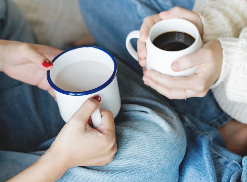 Residents having some warm cups of coffee while sitting on the floor at Sofi Lyndhurst in Lyndhurst, New Jersey