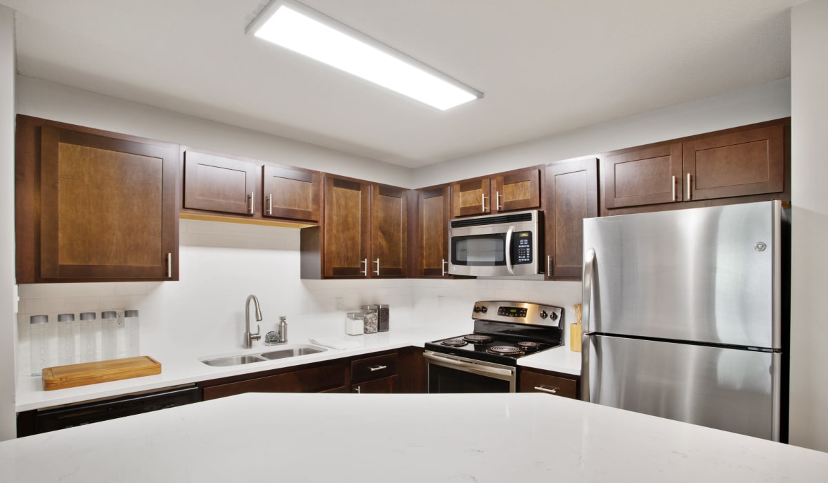 A kitchen with wood-style cabinets at The Barrington in Woodbury, Minnesota