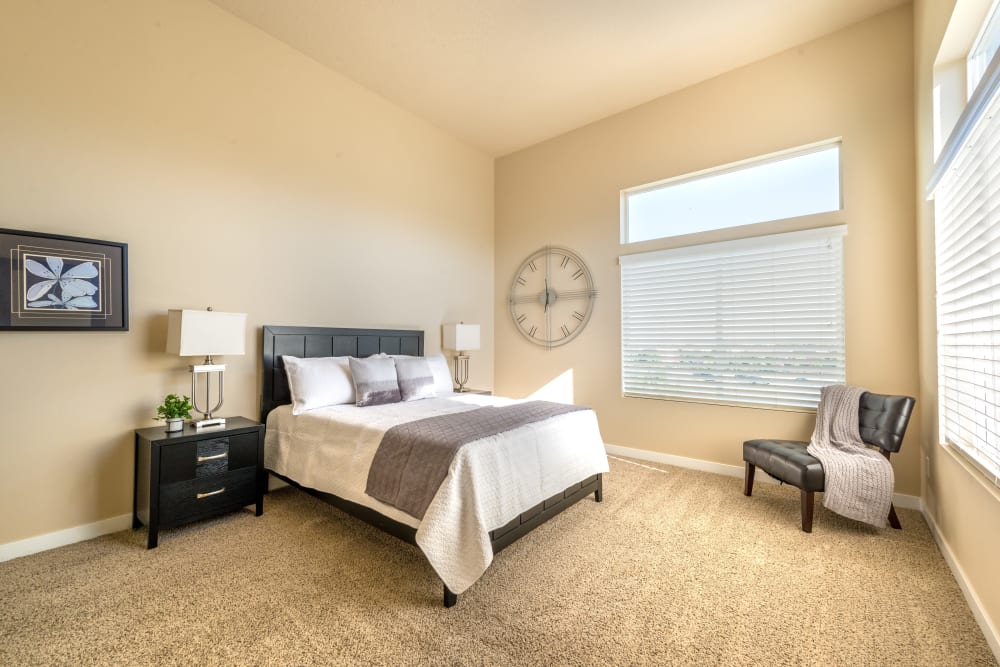 Well-lit bedroom with large bathroom at Olympus at the District in South Jordan, Utah