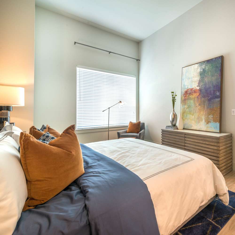 Well-designed apartment bedroom with comfortable bed at Hall Street Flats in Dallas, Texas