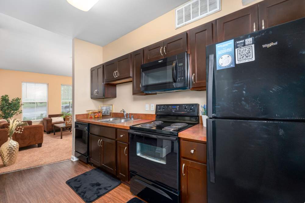 Kitchen with dark wood cabinet and black appliances at Mazza Grandmarc in College Park, Maryland