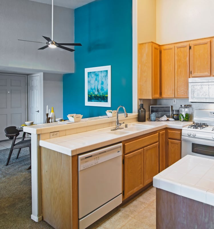 View of the dining area over the breakfast bar in a model home's kitchen at Sofi Canyon Hills in San Diego, California