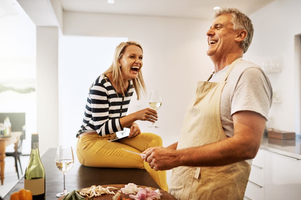 Happy mature couple keeping each other company in the kitchen at Trails of Towne Lake in Irving, Texas