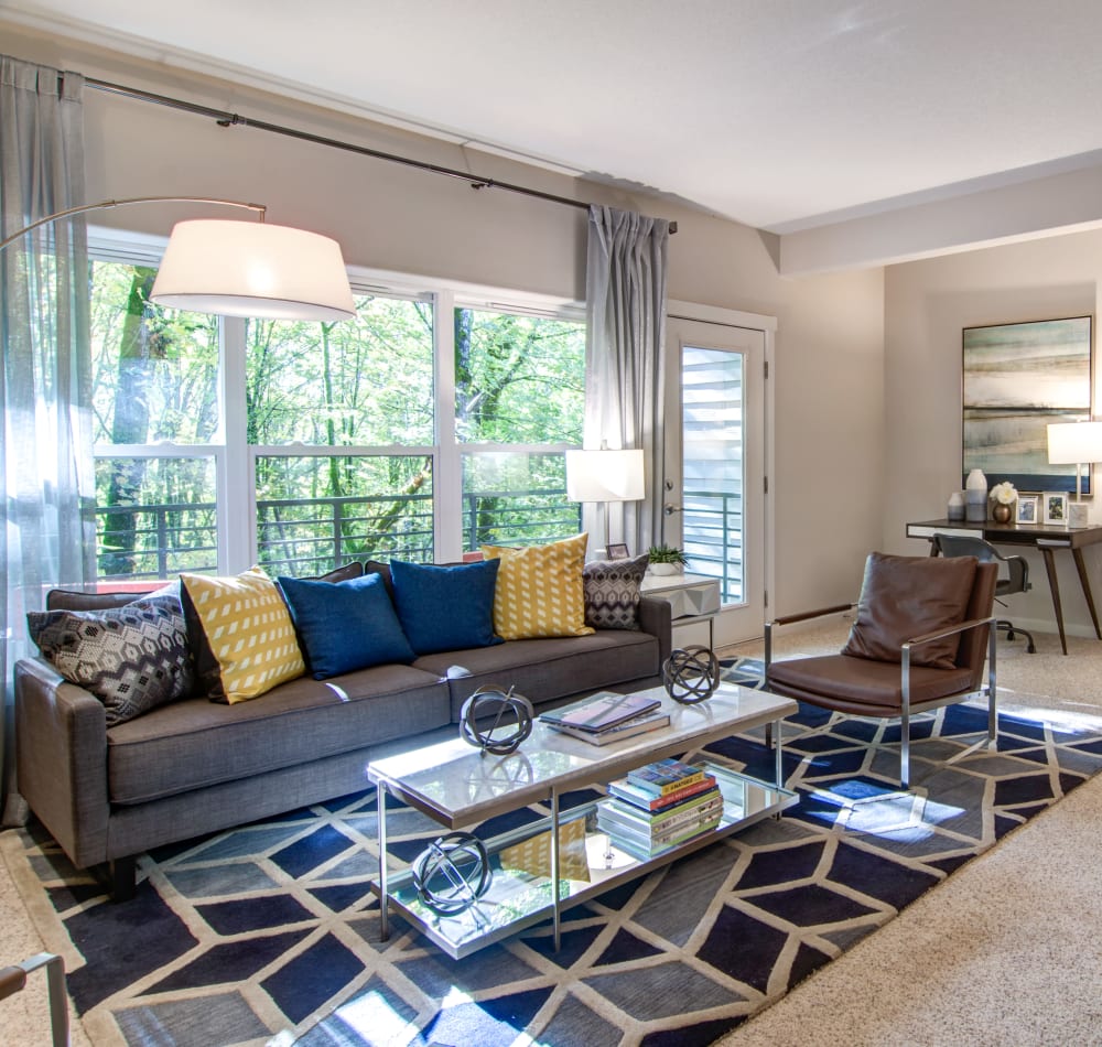 Open-concept layout with plush carpeting and modern furnishings in a model home's living area at Sofi at Forest Heights in Portland, Oregon