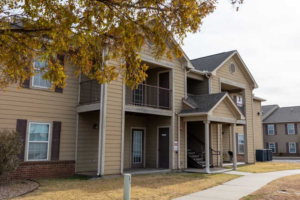 Charming apartment entrance with inviting architecture and lush landscaping at Adobe Ranch in Borger, Texas.