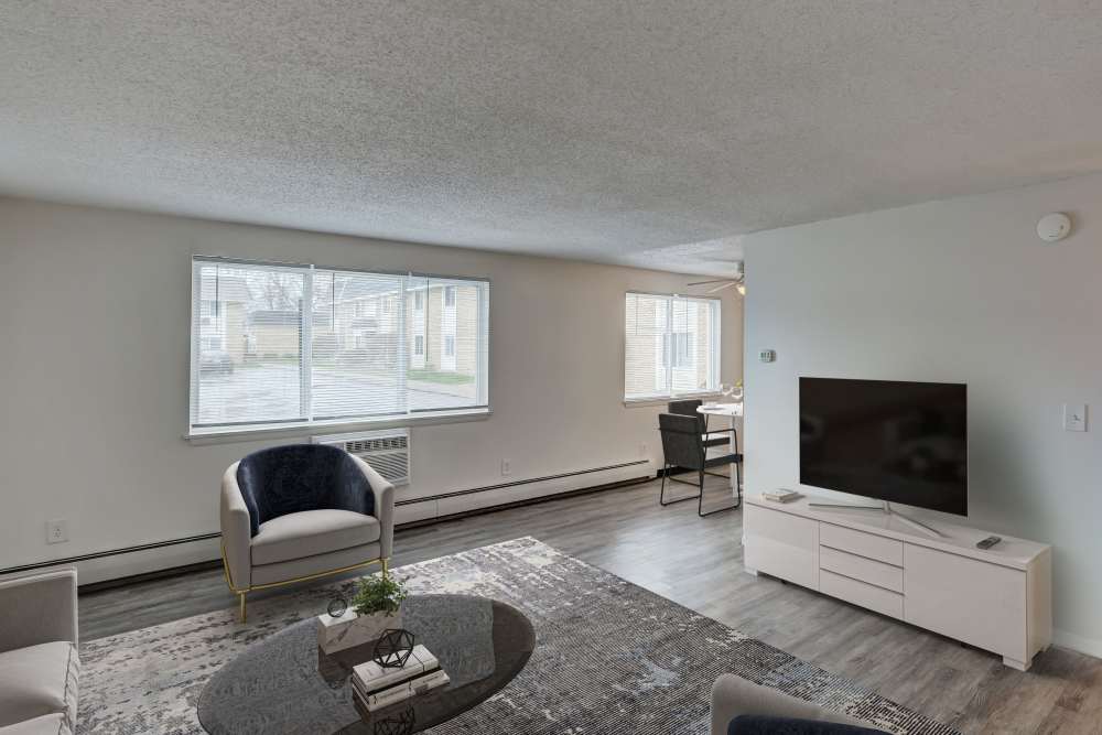 Bright living room with modern furniture, a window air conditioner and a television at Congress Apartment Homes in Allentown, Pennsylvania