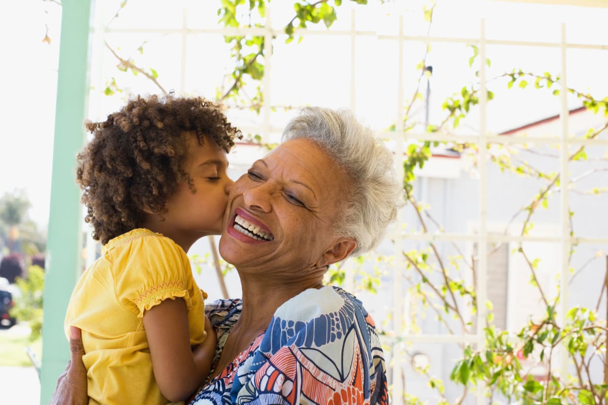 A resident enjoying time with her grandchild at a Meridian Senior Living community