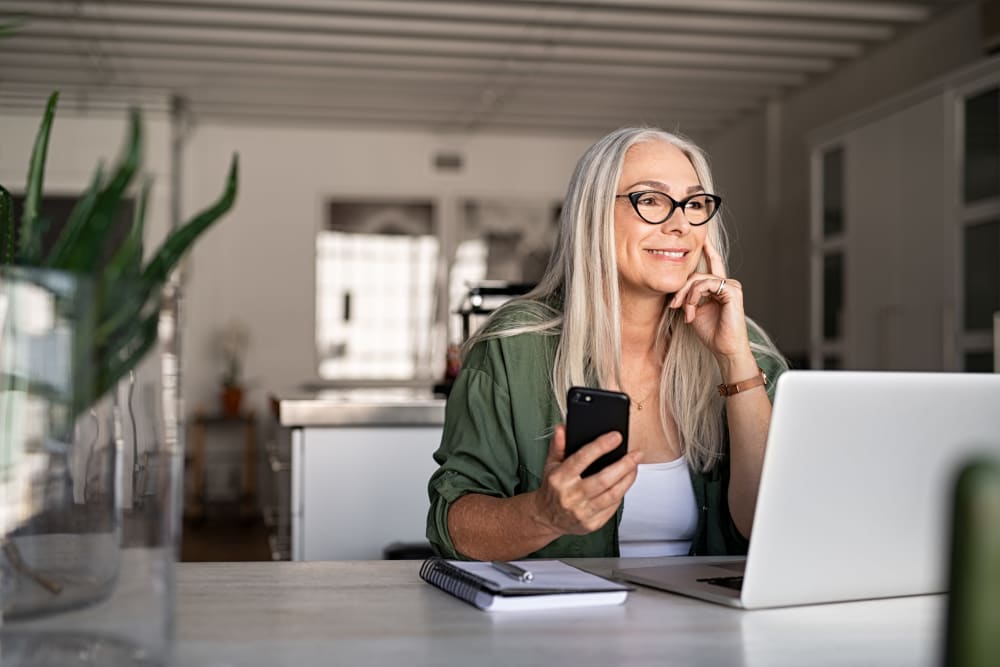 Independent living resident using a laptop in their apartment at Quail Park of Lynnwood in Lynnwood, Washington