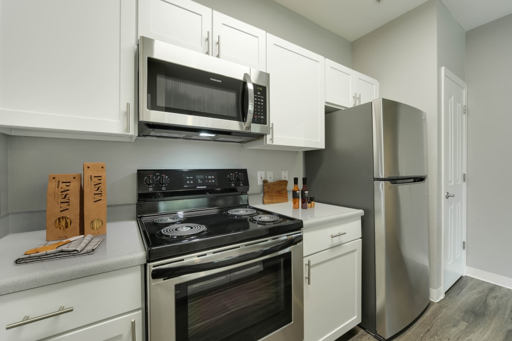 Kitchen with wood-style flooring and stainless steel appliances at The Grove at Orenco Station in Hillsboro, Oregon