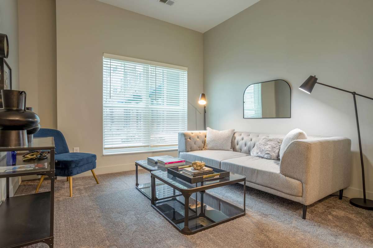 Living room with carpet flooring and large window at Gateway Lofts in Lansing, Michigan