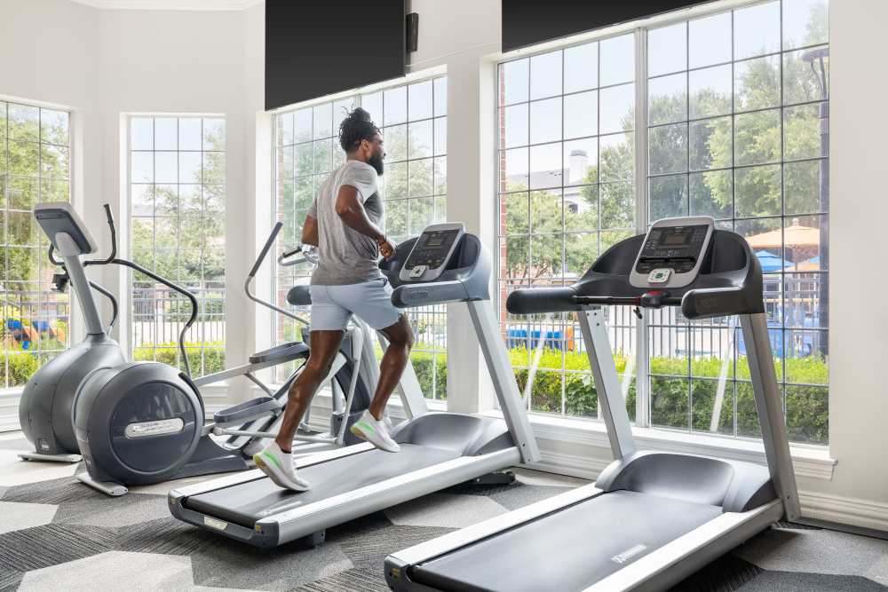 Person enjoying fitness center at Breckinridge Point Apartments in Richardson, TX