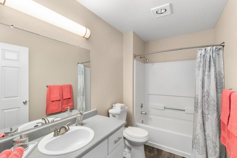 Updated bathroom with a large mirror and white cabinets at Carriage Park Apartments in Vancouver, Washington