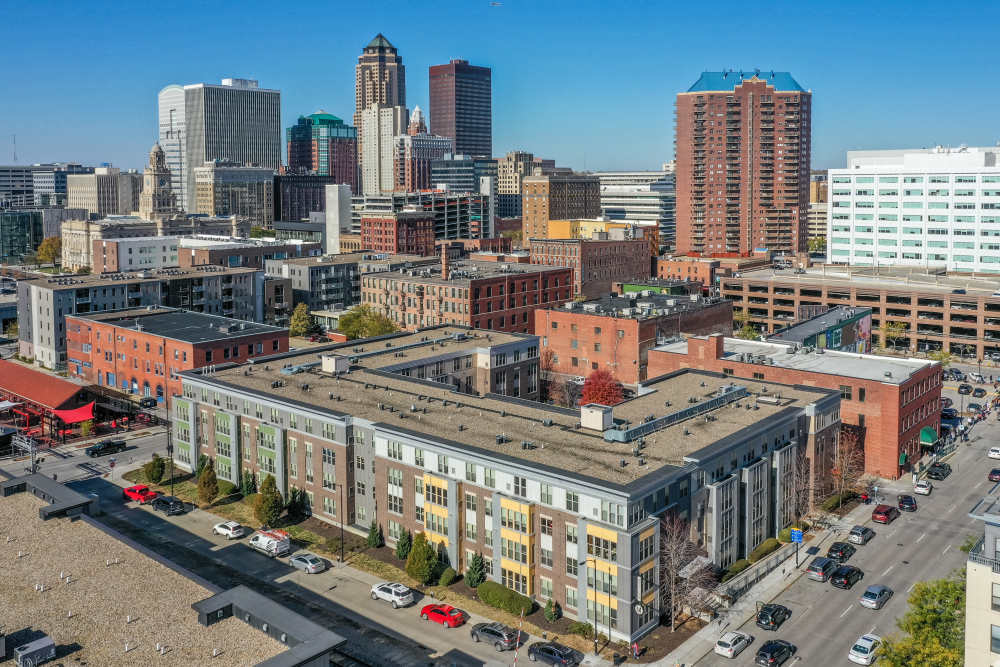 Modern apartment community with vibrant city skyline, featuring landscaped grounds and convenient parking options at Metro Lofts in Des Moines, Iowa