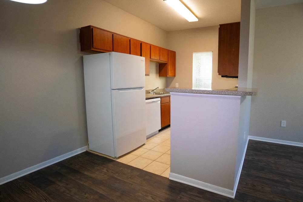Townhome kitchen with wooden cabinets and energy-efficient appliances at Millpoint Townhomes in Henderson, Texas