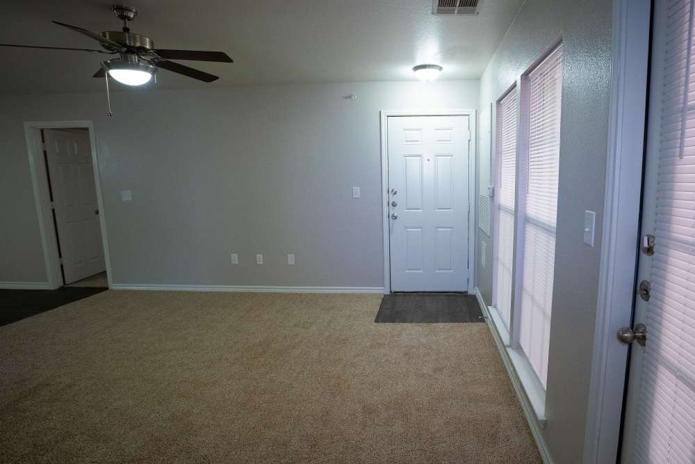 Unfurnished living room with ceiling fan and carpet flooring at Timber Village II in Marshall, Texas