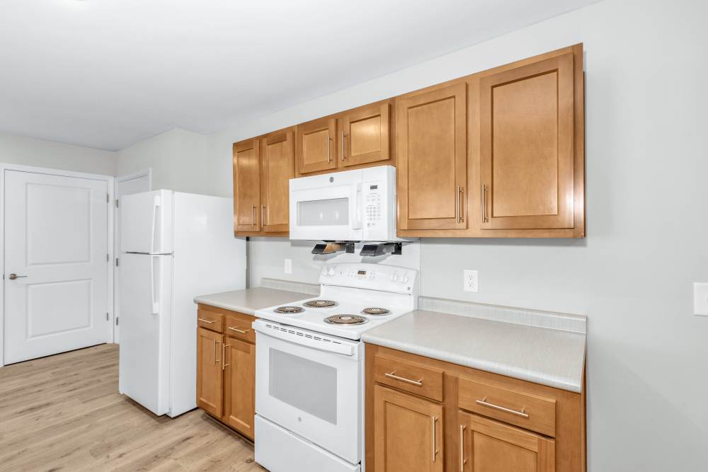 Wooden cabinets and white appliances of kitchen at The Lenox in Augusta, Georgia