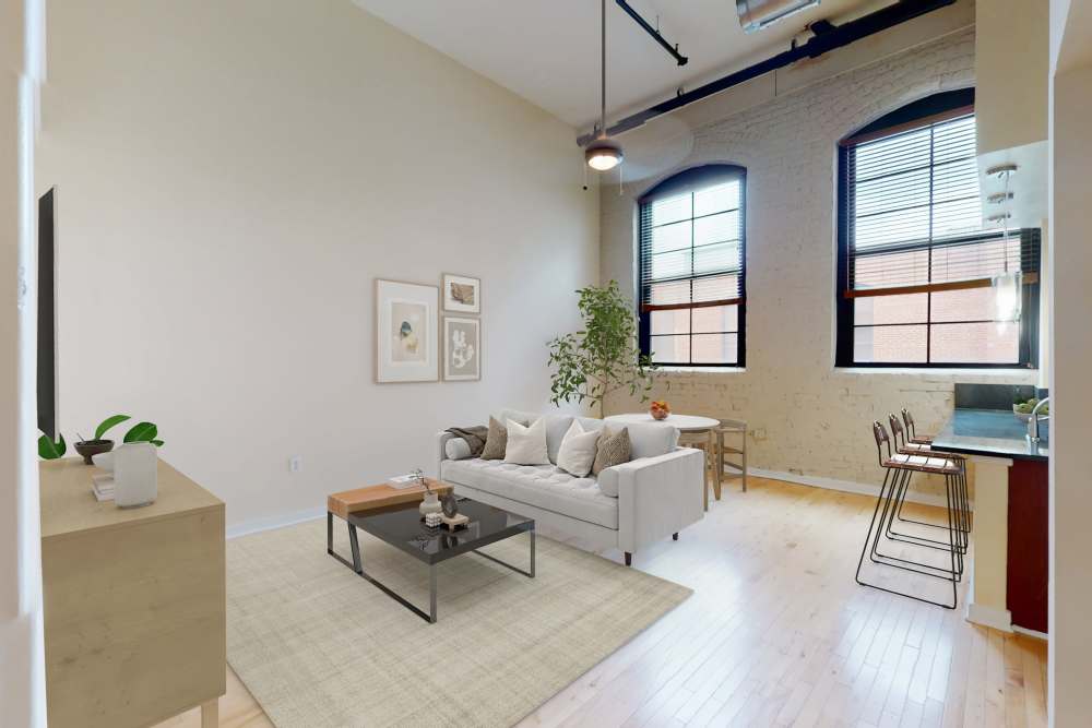 Well-lit and modern living area with comfy couch at Perry Street Lofts in Petersburg, Virginia