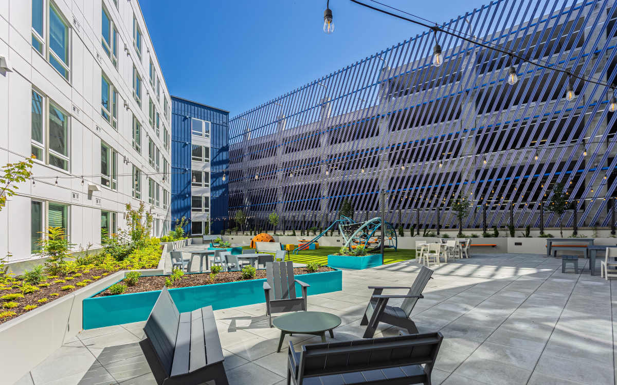 Outdoor community seating area with kids playground at Connection Angle Lake in SeaTac, Washington