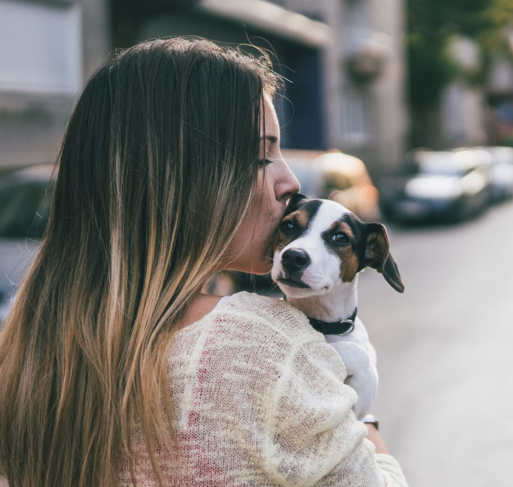 Resident giving her pup a kiss as she walks her through the neighborhood at Sofi at Morristown Station in Morristown, New Jersey