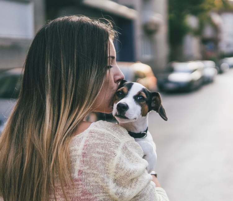 Resident giving her puppy a kiss outside their new home at Sofi Westview in San Diego, California