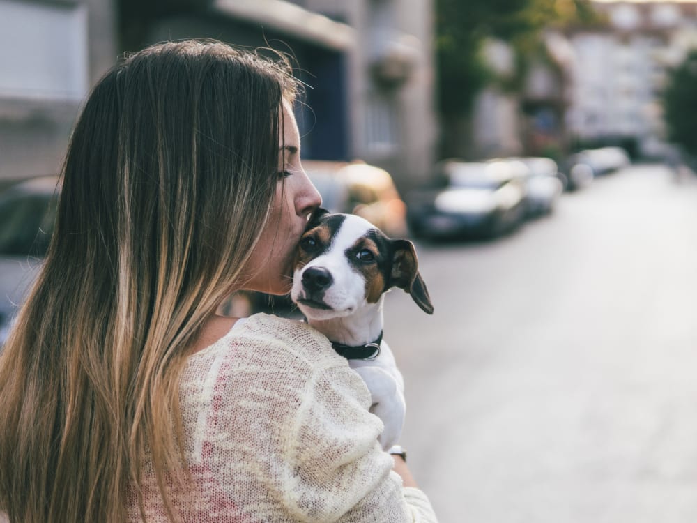 Resident giving her puppy a kiss outside their new home at Haven Martinez in Martinez, California