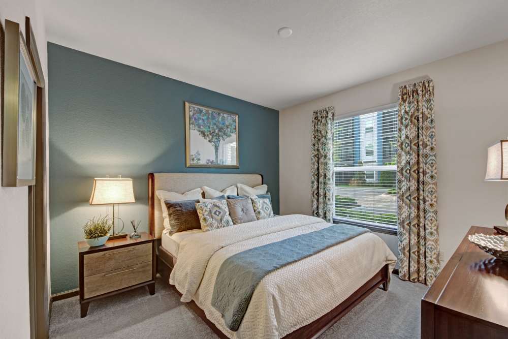 Comfortable bedroom with king size bed, large window and plush carpet flooring at The Courtney at Lake Shadow in Orlando, Florida 