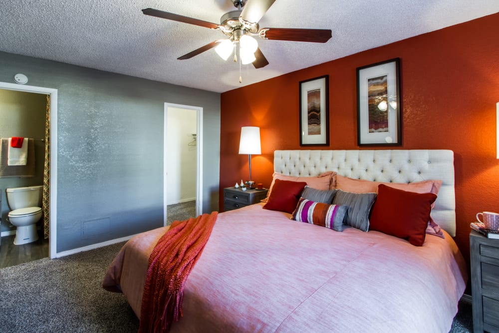 Model bedroom with bright accent wall at Sausalito Apartments in College Station, Texas