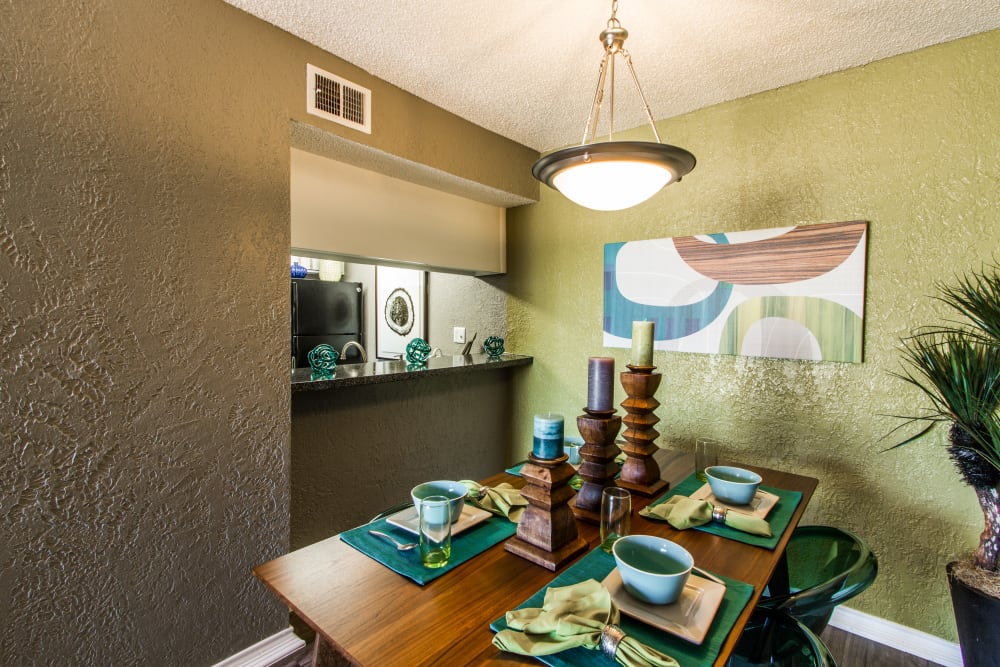 Kitchen with pass through window and model living room at Sundance Apartments in College Station, Texas