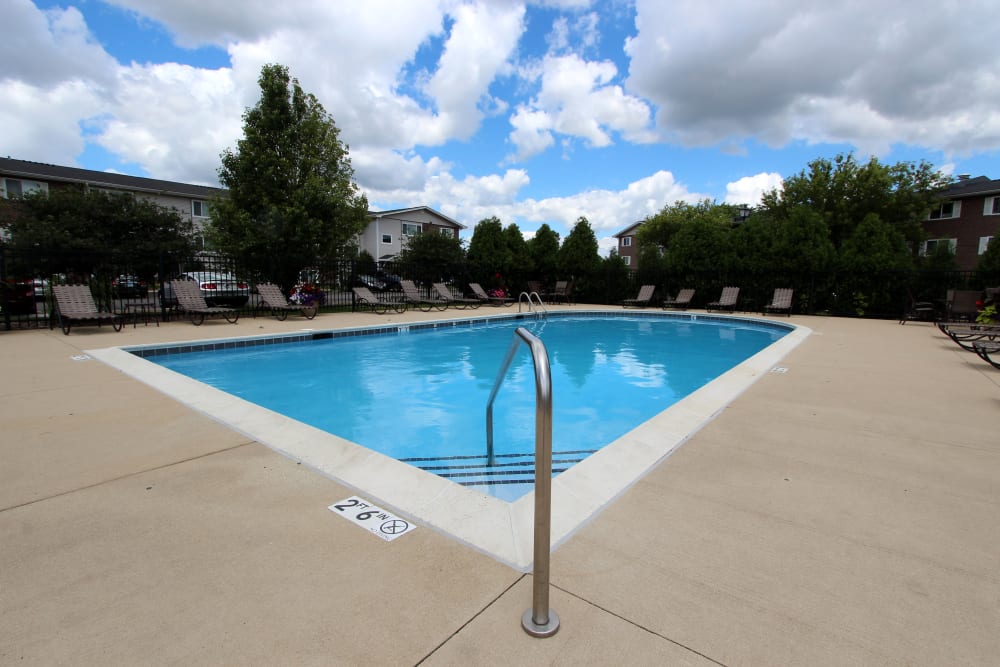 Beautiful resort-style swimming pool with lounge chairs at West Line Apartments in Hanover Park, Illinois