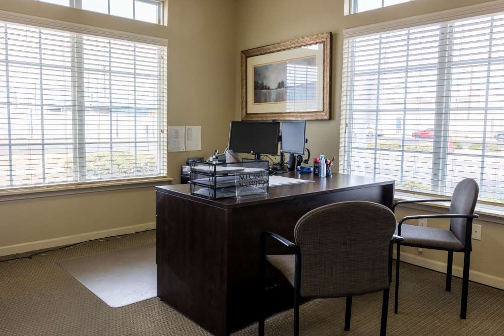 Bright and inviting workspace featuring large windows, organized desk, and a professional ambiance perfect for productivity at Adobe Ranch in Borger, Texas