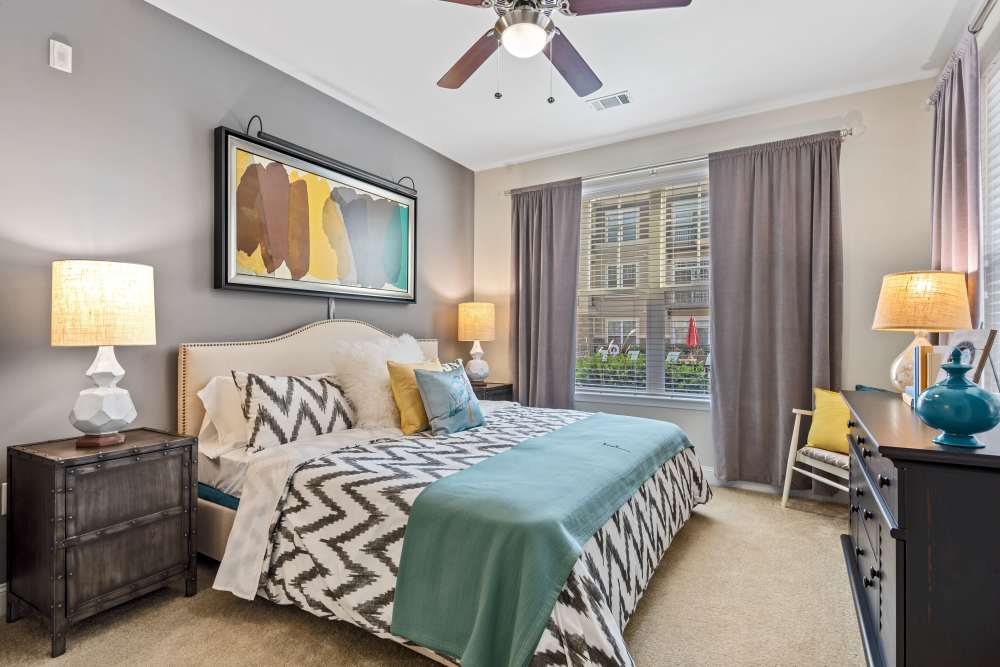 Well-lit modern bedroom with sophisticated furniture at Fountains at Mooresville Town Square in Mooresville, North Carolina