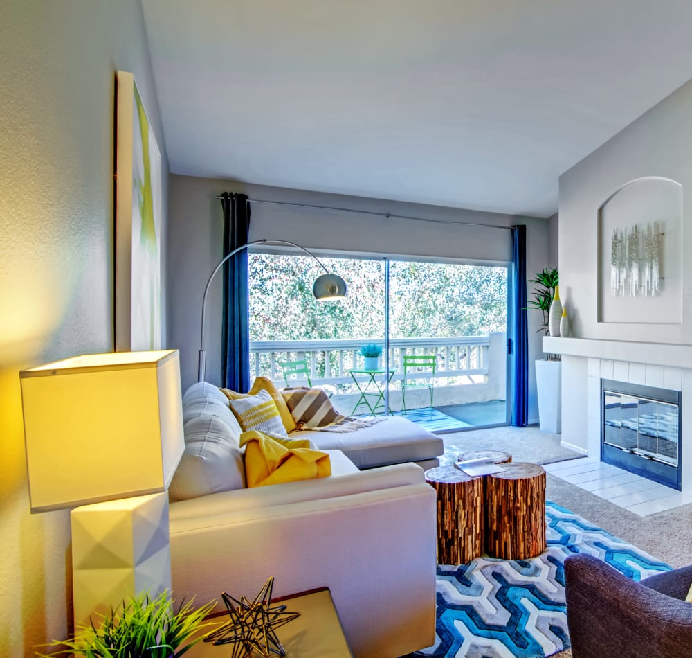 Modern furnishings, plush carpeting, and a fireplace in a model home at Sofi Canyon Hills in San Diego, California