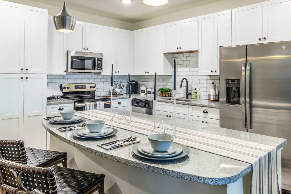Modern kitchen with white cabinets and island seating at Brisa at St. Augustine in St. Augustine, Florida