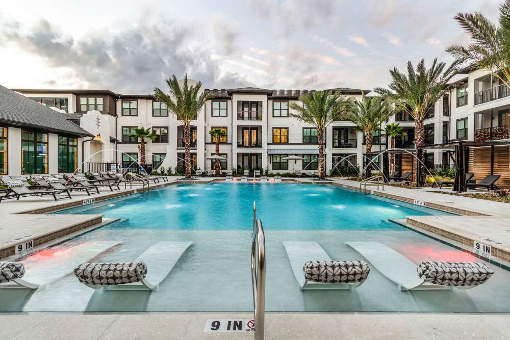 Swimming pool with lounge chairs and apartment buildings at Brisa at St. Augustine in St. Augustine, Florida