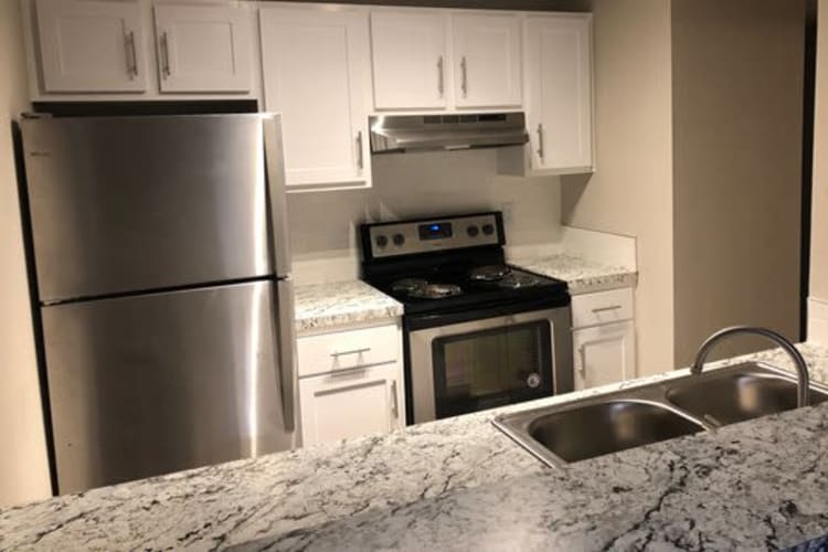 Modern kitchen with stainless-steel appliances in a model home at 1801 MetroWest in Orlando, Florida